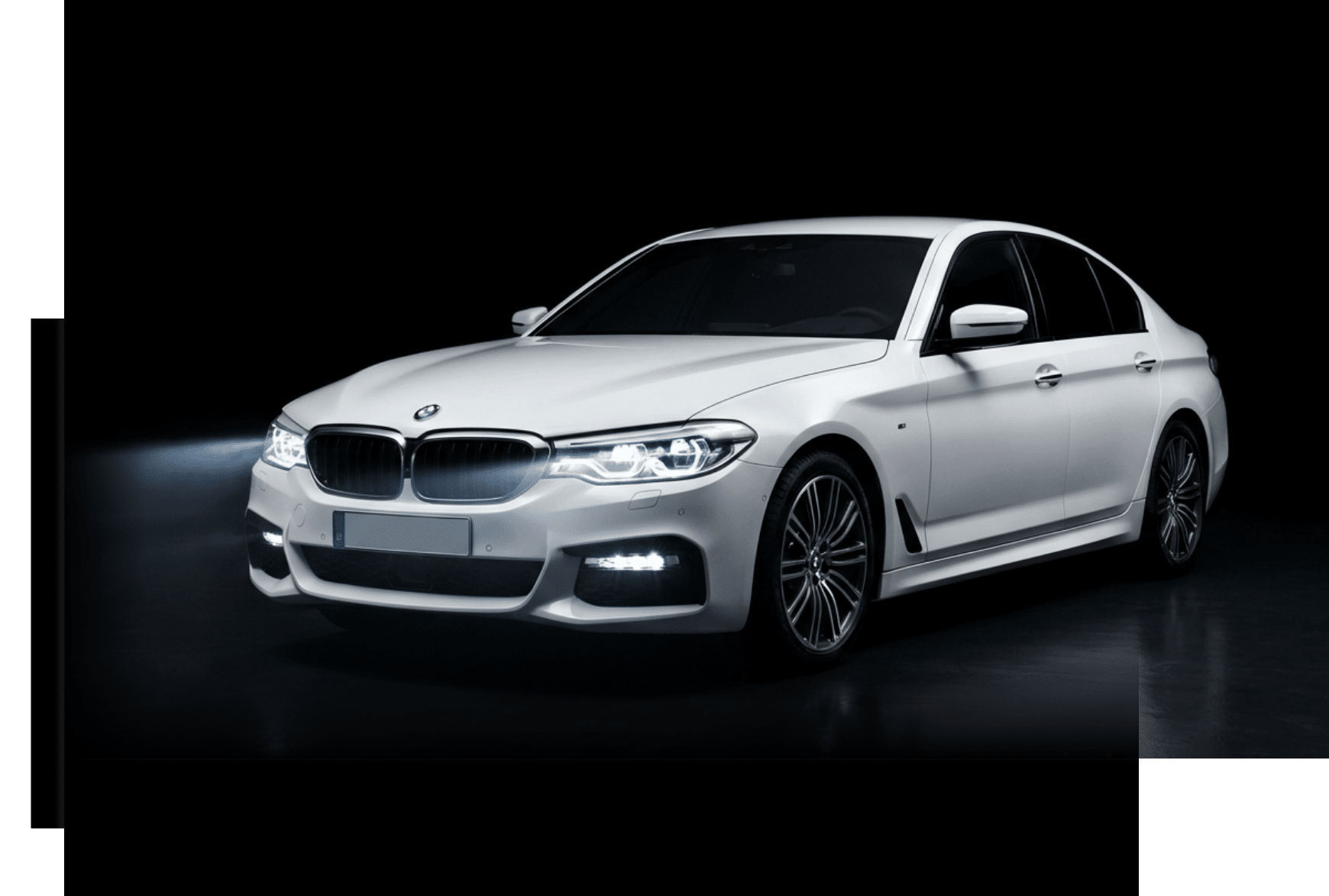 Weiße BMW Limousine mit eingeschalteten Scheinwerfern vor dunklem Hintergrund